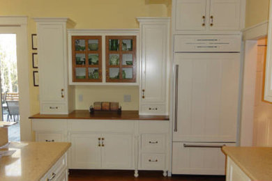 Photo of a medium sized u-shaped kitchen in Other with recessed-panel cabinets, white cabinets and an island.