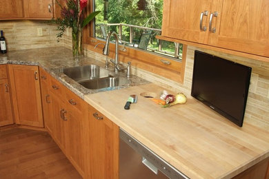 Eat-in kitchen - mid-sized craftsman l-shaped medium tone wood floor eat-in kitchen idea in New York with a double-bowl sink, shaker cabinets, medium tone wood cabinets, beige backsplash, matchstick tile backsplash, stainless steel appliances and an island
