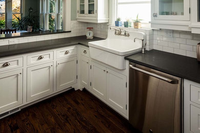 Large transitional dark wood floor kitchen photo in Other with a farmhouse sink, recessed-panel cabinets, white cabinets, granite countertops, white backsplash, subway tile backsplash, stainless steel appliances and an island