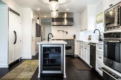 Eat-in kitchen - large transitional u-shaped dark wood floor eat-in kitchen idea in Los Angeles with an undermount sink, recessed-panel cabinets, white cabinets, marble countertops, white backsplash, cement tile backsplash, stainless steel appliances and an island