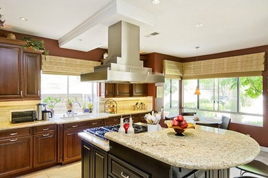 Contemporary kitchen in Orange County with raised-panel cabinets, medium wood cabinets, an island, a double-bowl sink, granite worktops, beige splashback, stone tiled splashback, stainless steel appliances and porcelain flooring.