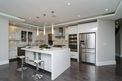Example of a mid-sized minimalist l-shaped painted wood floor eat-in kitchen design in Vancouver with an undermount sink, flat-panel cabinets, white cabinets, multicolored backsplash, stainless steel appliances, an island, matchstick tile backsplash and marble countertops