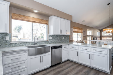 Mid-sized arts and crafts u-shaped light wood floor and gray floor open concept kitchen photo in Sacramento with a farmhouse sink, shaker cabinets, white cabinets, marble countertops, multicolored backsplash, glass tile backsplash, stainless steel appliances, an island and multicolored countertops