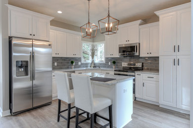 Transitional l-shaped eat-in kitchen photo in Omaha with an island