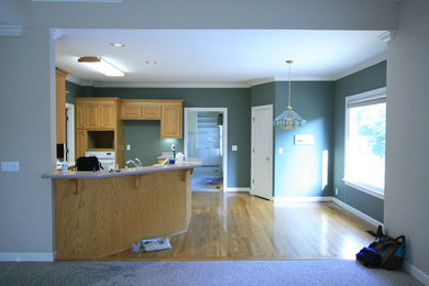 Example of a classic medium tone wood floor kitchen design in Nashville with a double-bowl sink, laminate countertops and white appliances