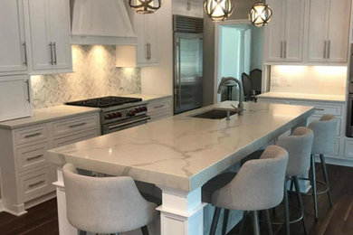 Mid-sized transitional u-shaped dark wood floor and brown floor eat-in kitchen photo in Other with an undermount sink, recessed-panel cabinets, white cabinets, marble countertops, white backsplash, marble backsplash, stainless steel appliances and an island