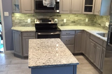 Kitchen - modern vinyl floor kitchen idea in Philadelphia with an undermount sink, granite countertops, mosaic tile backsplash, stainless steel appliances and an island