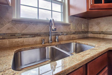 Kitchen - ceramic tile kitchen idea in Other with an undermount sink, medium tone wood cabinets, granite countertops, beige backsplash, ceramic backsplash and stainless steel appliances