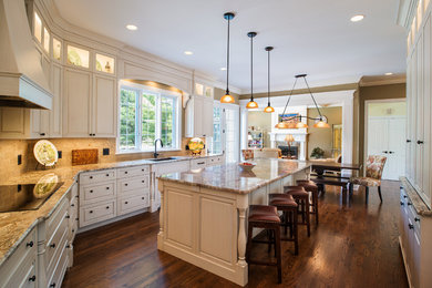 Inspiration for a large transitional medium tone wood floor and brown floor open concept kitchen remodel in Other with an undermount sink, stainless steel appliances, an island, white cabinets, granite countertops, beige backsplash and ceramic backsplash