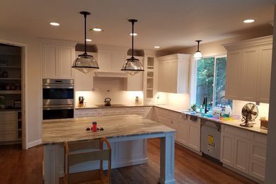 Large elegant galley light wood floor eat-in kitchen photo in Other with an undermount sink, louvered cabinets, white cabinets, granite countertops, white backsplash, window backsplash, stainless steel appliances, an island and gray countertops