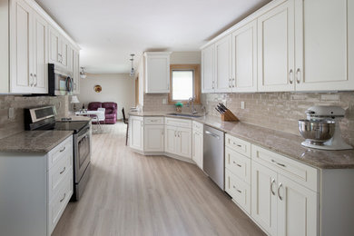 Example of a large transitional galley laminate floor and beige floor eat-in kitchen design in Milwaukee with a peninsula, an undermount sink, recessed-panel cabinets, beige cabinets, quartzite countertops, beige backsplash, subway tile backsplash, stainless steel appliances and beige countertops