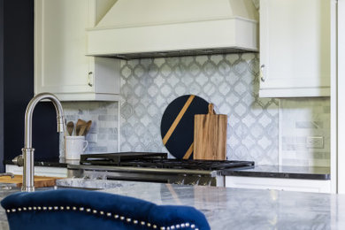 Diseño de cocina clásica renovada con fregadero sobremueble, armarios con paneles empotrados, puertas de armario blancas, encimera de cuarcita, salpicadero de mármol y una isla