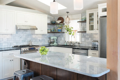 Exempel på ett klassiskt kök, med en undermonterad diskho, luckor med infälld panel, vita skåp, bänkskiva i kvarts, grått stänkskydd, stänkskydd i keramik, rostfria vitvaror, mörkt trägolv och en köksö