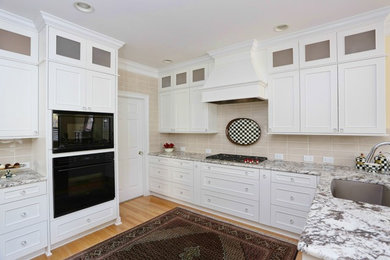 Example of a mid-sized transitional l-shaped medium tone wood floor and brown floor eat-in kitchen design in Raleigh with an undermount sink, recessed-panel cabinets, white cabinets, granite countertops, subway tile backsplash, black appliances, beige backsplash and multicolored countertops