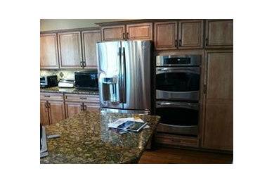 Eat-in kitchen - traditional l-shaped eat-in kitchen idea in Detroit with an undermount sink, raised-panel cabinets, granite countertops, stainless steel appliances, an island, medium tone wood cabinets, multicolored backsplash, stone tile backsplash and multicolored countertops