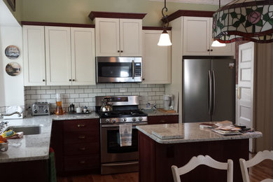 Kitchen - l-shaped medium tone wood floor kitchen idea in New York with an undermount sink, shaker cabinets, granite countertops, white backsplash, subway tile backsplash, stainless steel appliances and an island