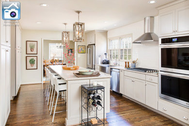 Kitchen pantry - mid-sized modern galley medium tone wood floor kitchen pantry idea in Birmingham with a farmhouse sink, beaded inset cabinets, beige cabinets, granite countertops, white backsplash, glass tile backsplash, stainless steel appliances and an island