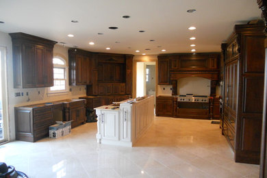 Example of a large classic u-shaped ceramic tile and beige floor enclosed kitchen design in Louisville with raised-panel cabinets, dark wood cabinets, beige backsplash, stainless steel appliances and an island
