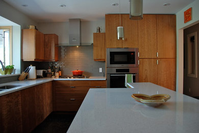 Example of a mid-sized trendy kitchen design in Calgary with a double-bowl sink, flat-panel cabinets, medium tone wood cabinets, quartzite countertops, gray backsplash, stainless steel appliances and an island