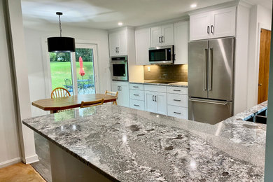 Small transitional u-shaped vinyl floor and gray floor eat-in kitchen photo in Milwaukee with a double-bowl sink, shaker cabinets, white cabinets, granite countertops, gray backsplash, glass tile backsplash, stainless steel appliances, a peninsula and gray countertops