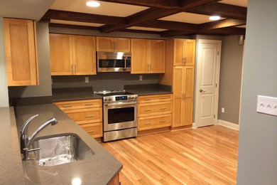 Enclosed kitchen - mid-sized traditional medium tone wood floor and brown floor enclosed kitchen idea in Other with a single-bowl sink, shaker cabinets, light wood cabinets, quartz countertops, stainless steel appliances and no island