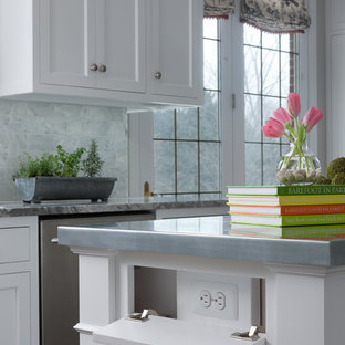 Design ideas for a mid-sized traditional u-shaped eat-in kitchen in Detroit with an undermount sink, shaker cabinets, white cabinets, zinc benchtops, grey splashback, marble splashback, stainless steel appliances, medium hardwood floors, with island and brown floor.
