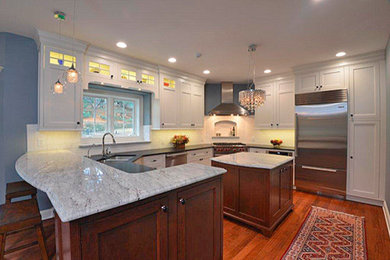 Example of a large trendy u-shaped medium tone wood floor eat-in kitchen design in Philadelphia with an undermount sink, beaded inset cabinets, white cabinets, granite countertops, white backsplash, subway tile backsplash, stainless steel appliances and an island