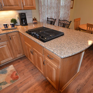 Photo of an u-shaped eat-in kitchen in Cleveland with an undermount sink, raised-panel cabinets, medium wood cabinets, quartz benchtops, white splashback, ceramic splashback, stainless steel appliances, vinyl floors, no island and brown floor.