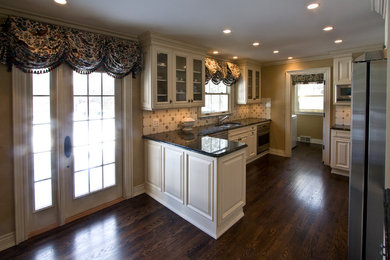 Eat-in kitchen - mid-sized traditional u-shaped dark wood floor eat-in kitchen idea in Detroit with a double-bowl sink, raised-panel cabinets, white cabinets, granite countertops, white backsplash, mosaic tile backsplash, stainless steel appliances and a peninsula