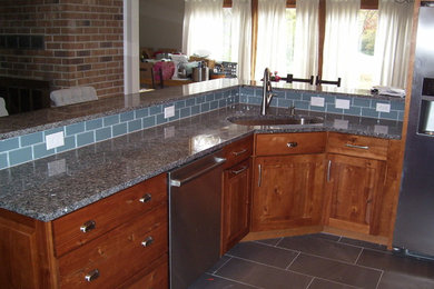 Example of a small classic u-shaped ceramic tile kitchen design in DC Metro with a single-bowl sink, raised-panel cabinets, distressed cabinets, granite countertops, gray backsplash, glass tile backsplash and stainless steel appliances