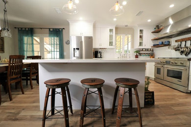 Mid-sized l-shaped eat-in kitchen photo in Orange County with an island