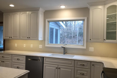 Kitchen photo in St Louis with an undermount sink, raised-panel cabinets, white cabinets, quartz countertops, an island and white countertops