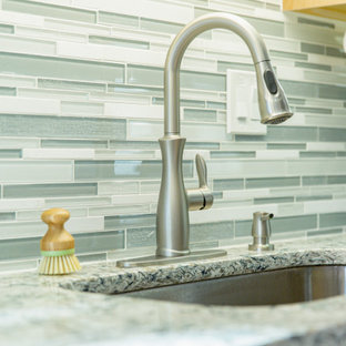 Large modern galley eat-in kitchen in DC Metro with an undermount sink, shaker cabinets, light wood cabinets, quartz benchtops, green splashback, glass tile splashback, black appliances, porcelain floors, with island, brown floor and green benchtop.