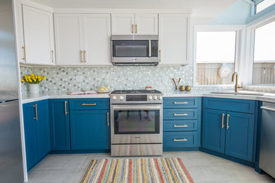 Example of a minimalist u-shaped ceramic tile and gray floor enclosed kitchen design in San Francisco with a double-bowl sink, recessed-panel cabinets, blue cabinets, quartzite countertops, multicolored backsplash, glass tile backsplash, stainless steel appliances, a peninsula and white countertops