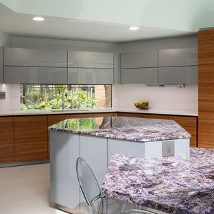 Mittelgroße Moderne Wohnküche mit Unterbauwaschbecken, flächenbündigen Schrankfronten, hellbraunen Holzschränken, Mineralwerkstoff-Arbeitsplatte, Küchengeräten aus Edelstahl, Porzellan-Bodenfliesen, Kücheninsel, weißem Boden und lila Arbeitsplatte in Houston