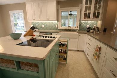 Mid-sized elegant u-shaped porcelain tile kitchen photo in Charlotte with a farmhouse sink, raised-panel cabinets, white cabinets, quartz countertops, blue backsplash, stainless steel appliances and an island