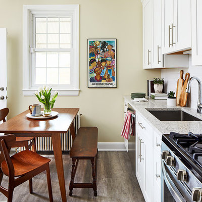 Inspiration for a timeless single-wall brown floor eat-in kitchen remodel in DC Metro with an undermount sink, shaker cabinets, white cabinets, white backsplash, subway tile backsplash, stainless steel appliances, no island and multicolored countertops
