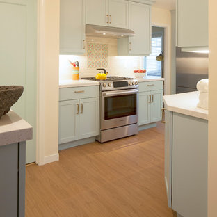 Mid-sized southwestern kitchen ideas - Example of a mid-sized southwest galley beige floor kitchen design in San Francisco with an undermount sink, flat-panel cabinets, blue cabinets, quartz countertops, white backsplash, porcelain backsplash and stainless steel appliances