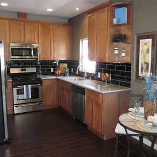 Photo of a small traditional u-shaped eat-in kitchen in San Francisco with an undermount sink, shaker cabinets, medium wood cabinets, granite benchtops, black splashback, stainless steel appliances, dark hardwood floors, no island and subway tile splashback.