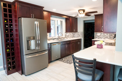 Example of a mid-sized transitional galley porcelain tile eat-in kitchen design in Chicago with an undermount sink, shaker cabinets, dark wood cabinets, solid surface countertops, white backsplash, mosaic tile backsplash, colored appliances and a peninsula