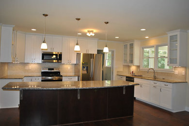 Example of a large transitional l-shaped dark wood floor and brown floor eat-in kitchen design in Other with an undermount sink, shaker cabinets, white cabinets, granite countertops, beige backsplash, stainless steel appliances and an island