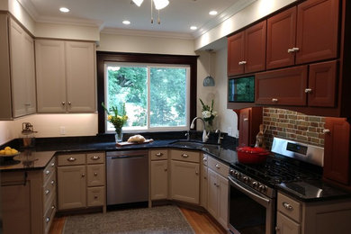 Inredning av ett klassiskt mellanstort svart svart kök, med en dubbel diskho, luckor med infälld panel, grå skåp, bänkskiva i kvarts, brunt stänkskydd, stänkskydd i tegel, rostfria vitvaror, mellanmörkt trägolv och brunt golv