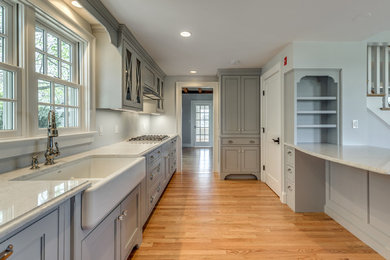 Mid-sized l-shaped medium tone wood floor and brown floor eat-in kitchen photo in Boston with an undermount sink, shaker cabinets, white cabinets, granite countertops, gray backsplash, ceramic backsplash, stainless steel appliances and an island