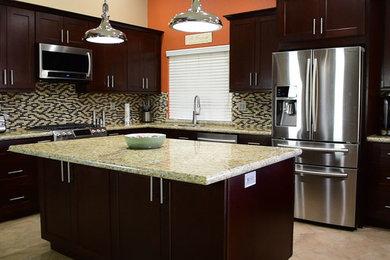 Large transitional l-shaped ceramic tile and beige floor kitchen photo in Los Angeles with an undermount sink, shaker cabinets, dark wood cabinets, granite countertops, multicolored backsplash, glass tile backsplash, stainless steel appliances, an island and multicolored countertops