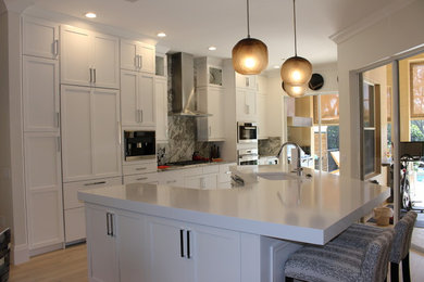 Example of a minimalist kitchen design with stainless steel appliances and an island
