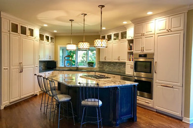 Large transitional u-shaped dark wood floor and brown floor eat-in kitchen photo in Chicago with an undermount sink, raised-panel cabinets, white cabinets, quartz countertops, gray backsplash, stone tile backsplash, paneled appliances, an island and gray countertops