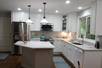 Inspiration for a large modern u-shaped medium tone wood floor and brown floor eat-in kitchen remodel in St Louis with an undermount sink, recessed-panel cabinets, white cabinets, quartzite countertops, white backsplash, ceramic backsplash, stainless steel appliances, an island and white countertops