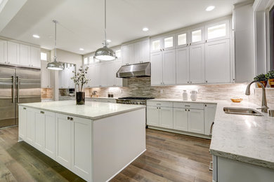 Mid-sized transitional u-shaped medium tone wood floor and brown floor open concept kitchen photo in Los Angeles with a double-bowl sink, shaker cabinets, white cabinets, granite countertops, beige backsplash, matchstick tile backsplash, stainless steel appliances, an island and gray countertops