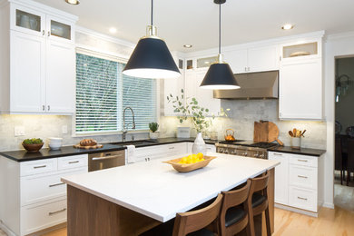 Mid-sized transitional l-shaped light wood floor and brown floor eat-in kitchen photo in Seattle with an undermount sink, shaker cabinets, white cabinets, quartz countertops, multicolored backsplash, marble backsplash, stainless steel appliances and an island