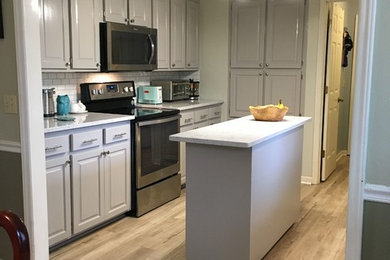 Inspiration for a mid-sized contemporary galley light wood floor and beige floor eat-in kitchen remodel in Other with an undermount sink, raised-panel cabinets, gray cabinets, quartz countertops, white backsplash, subway tile backsplash, stainless steel appliances, an island and white countertops